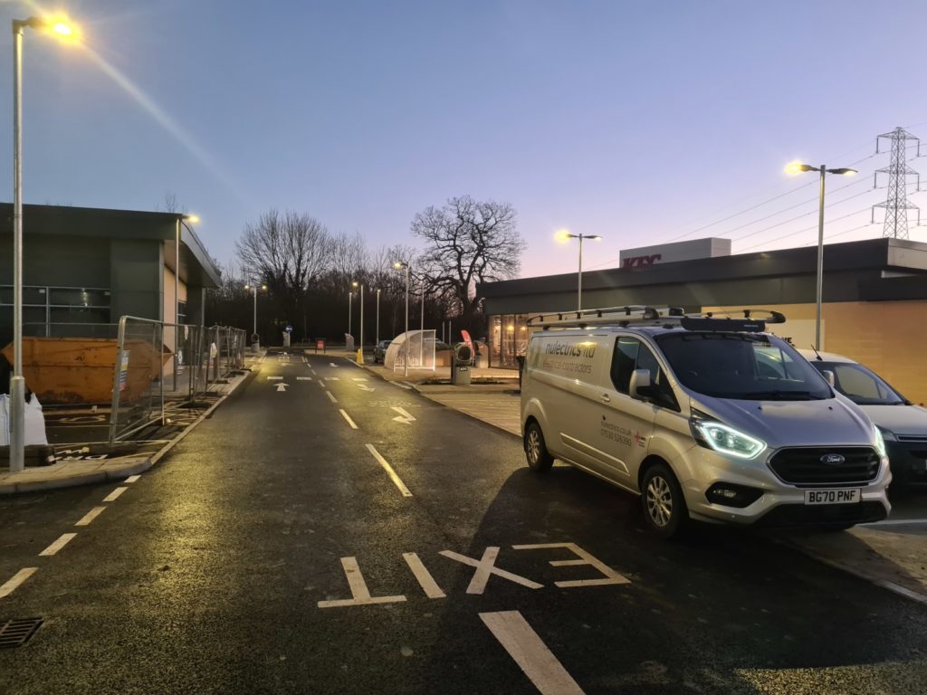 Nulectrics van in KFC Costa car park Bath Road in Chippenham. Lamp post lights on in wet weather.