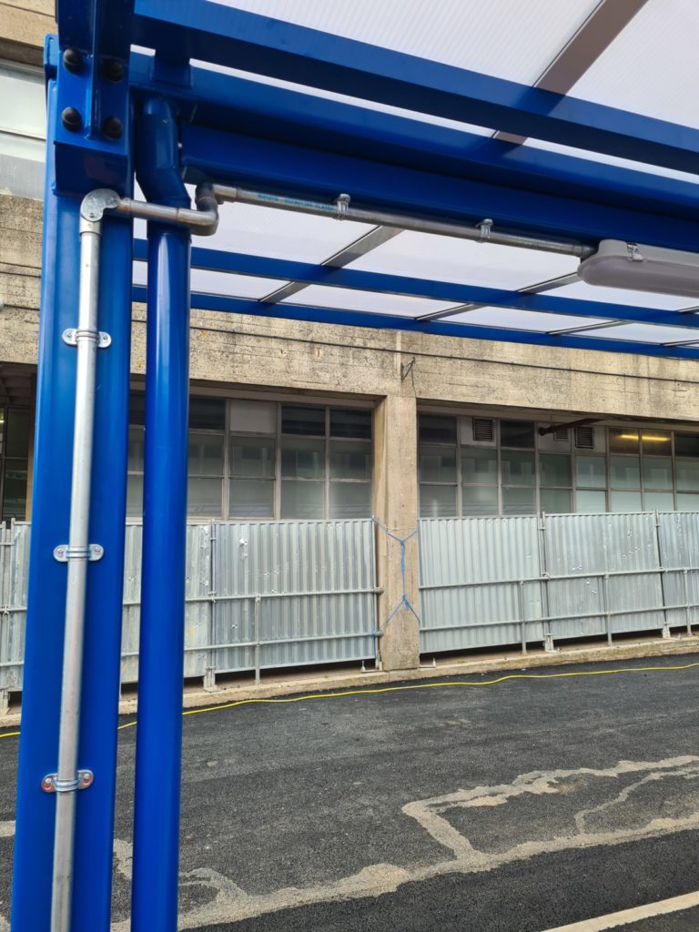 Galvanised conduit and flexible metal conduit hugging the canopy
