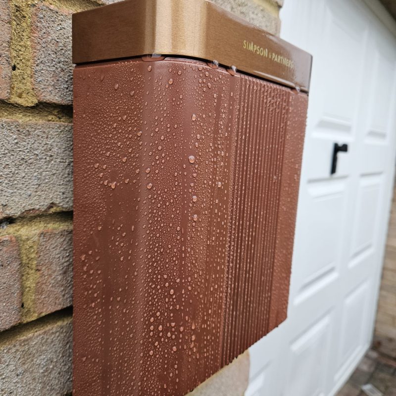 Side view of the copper charge point against the brickwork