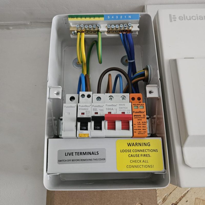 Inside: 100A main switch, Type A RCBO and an SPD on the charger circuit