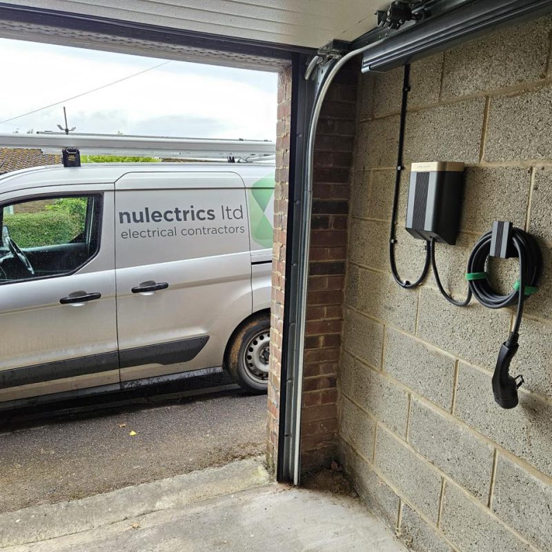 Just inside the entrance, so the car charges with the door raised